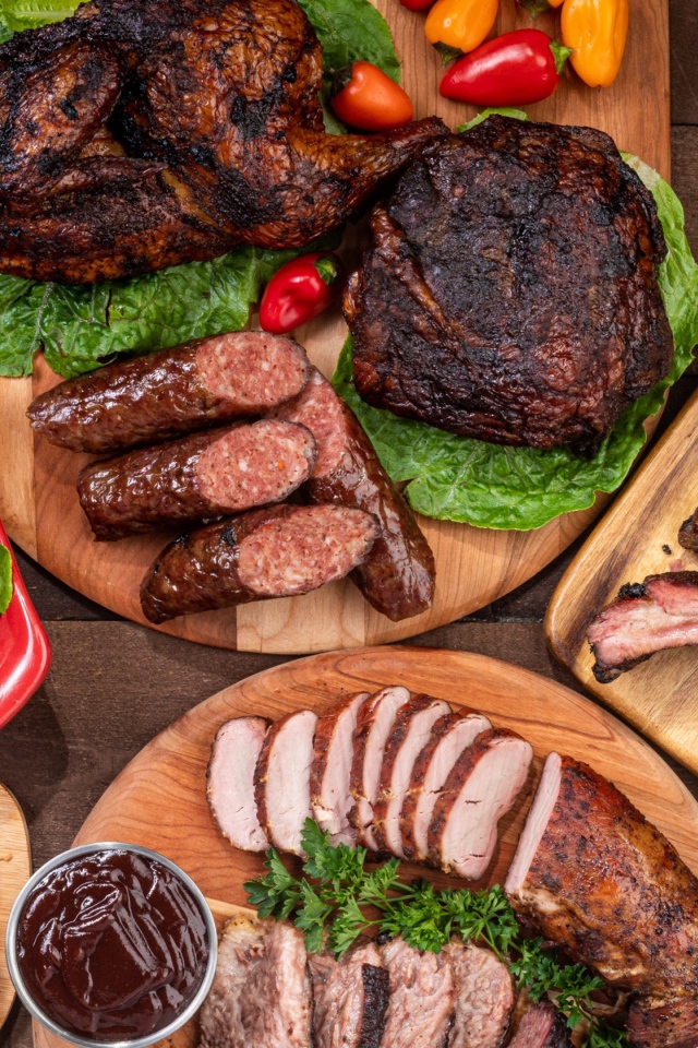 Вкусные запеченные мясные продукты на столе с овощами 