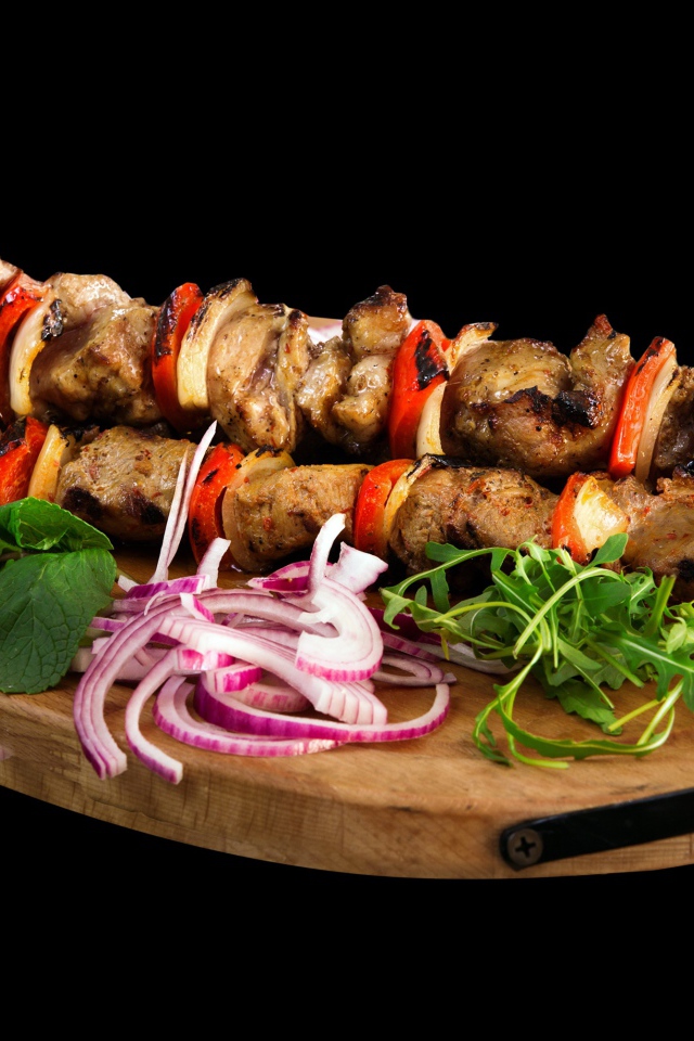 Вкусный шашлык на доске с луком и зеленью 