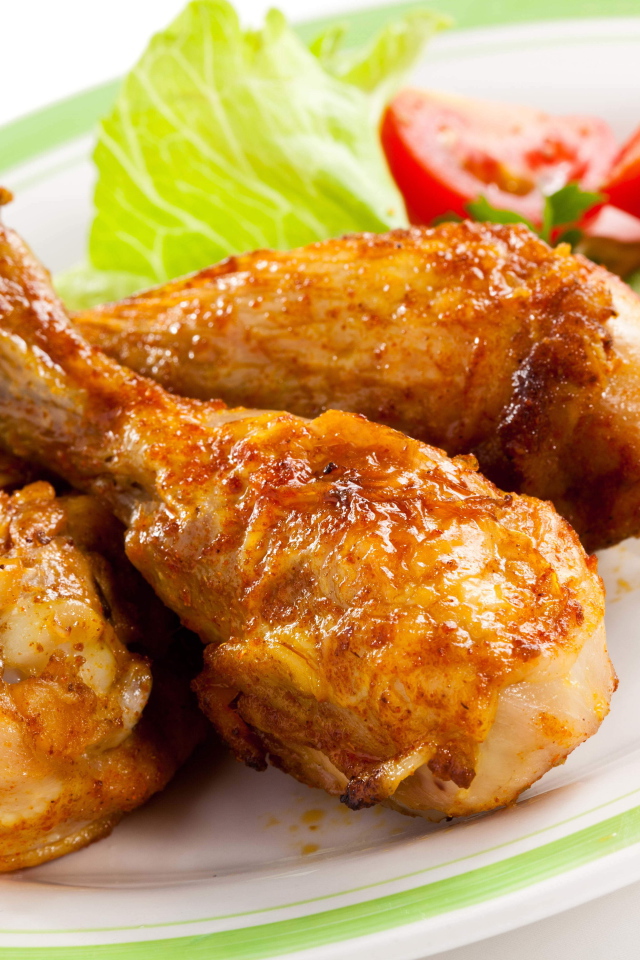 Зажареные куриные ножки на тарелке с овощами