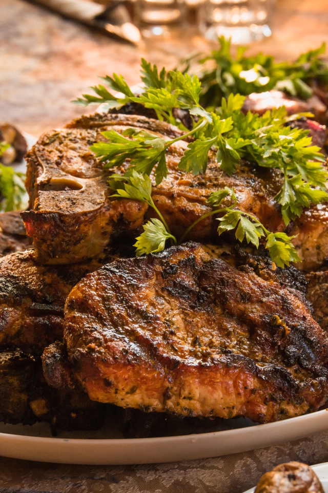 Много жареного мяса на тарелке с петрушкой 