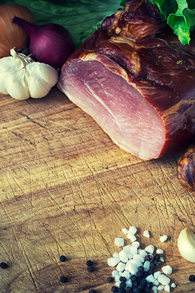 Мясные продукты на столе со специями, луком и чесноком 