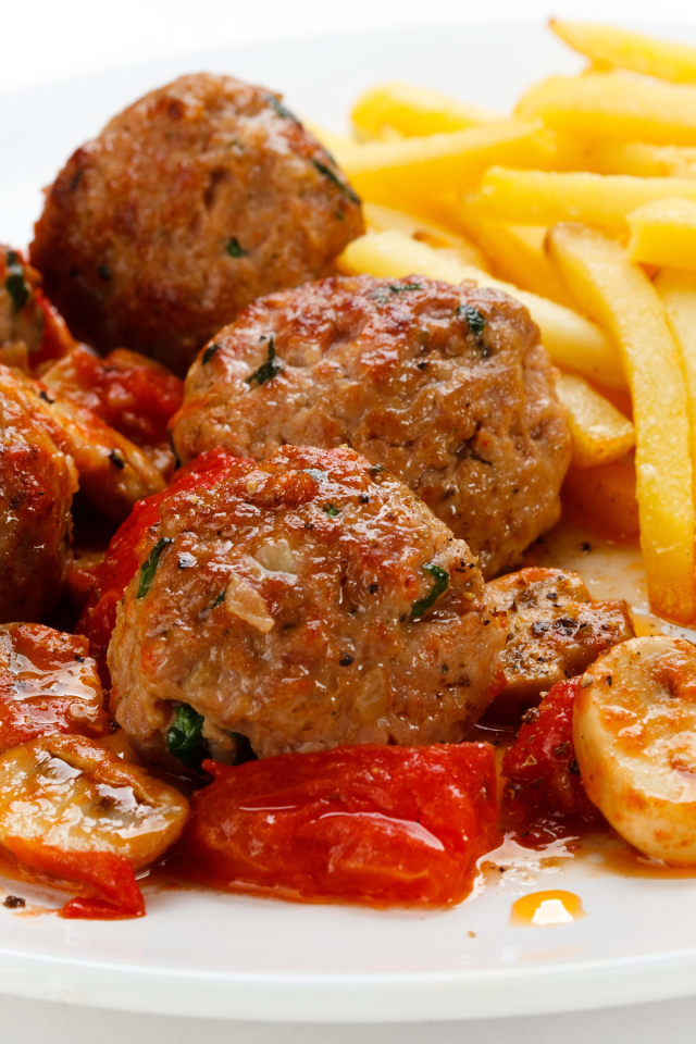 Тефтели с картофелем фри и овощами на белом фоне