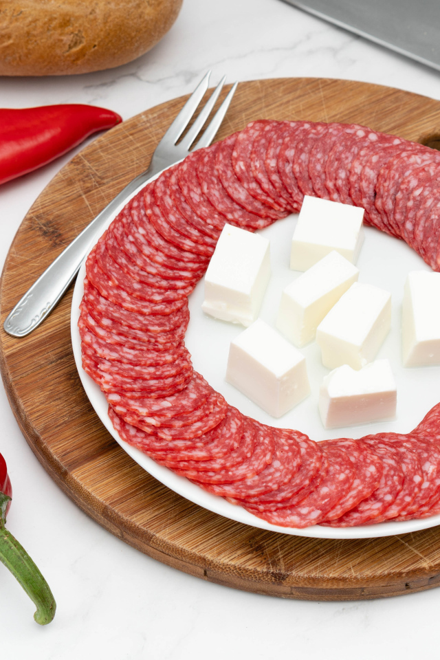 Колбаса с сыром на столе с красным сладким перцем