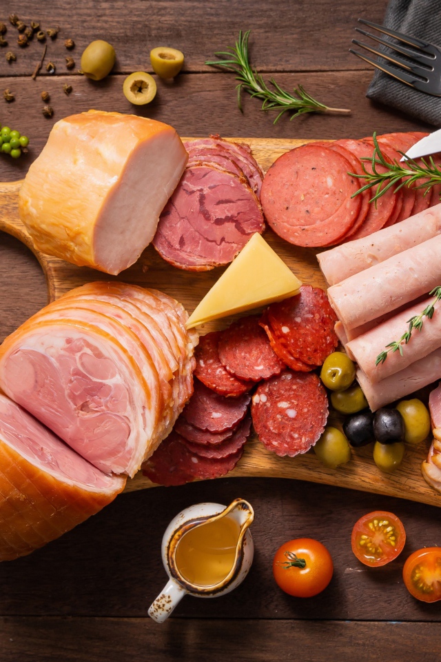 Колбасы и мясные продукты на доске со специями