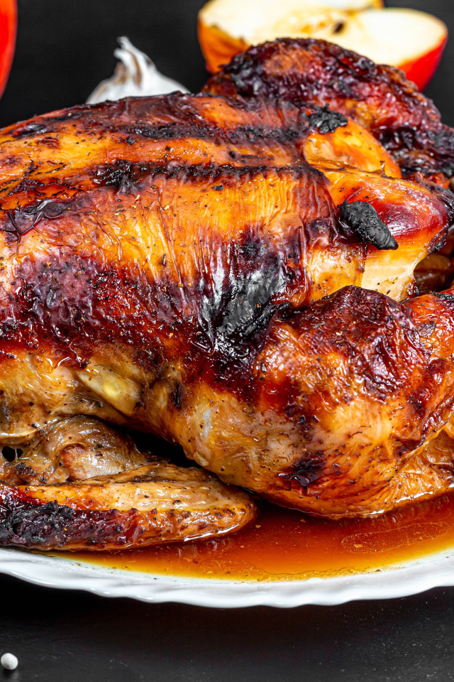 Вкусная запеченная курица на белой тарелке на столе с овощами