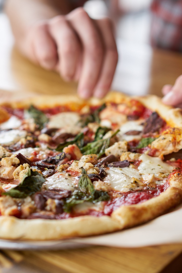 Мужчина в кафе ест вкусную горячую пиццу 