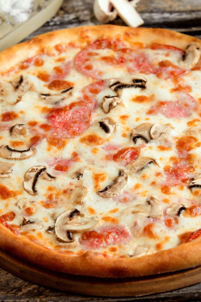 Вкусная пицца с грибами, колбасой и сыром