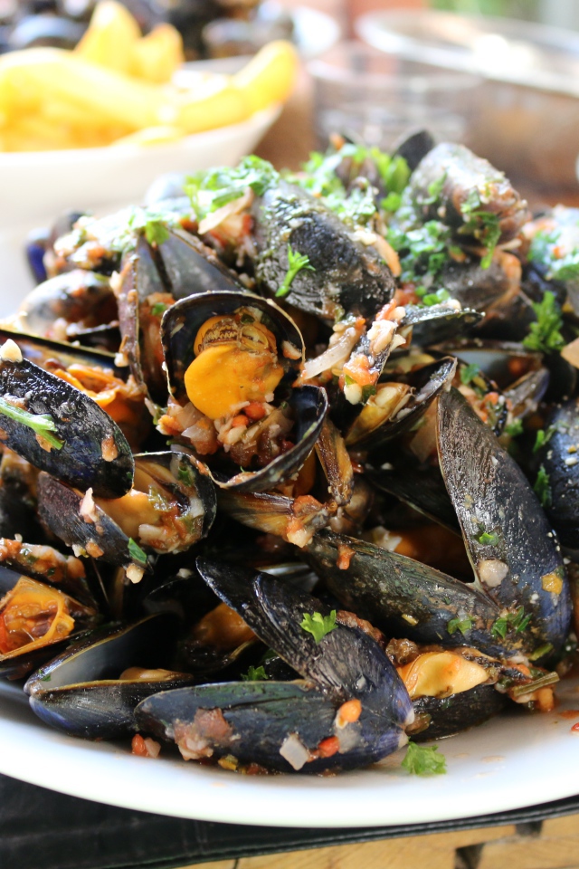 Мидии на  белой тарелке со специями 