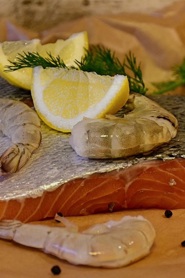 Кусок красной рыбы с креветками и лимонами