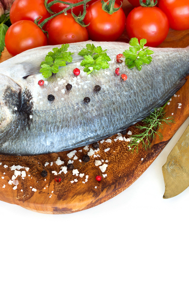 Сырая рыба на столе с маслом и помидорами 