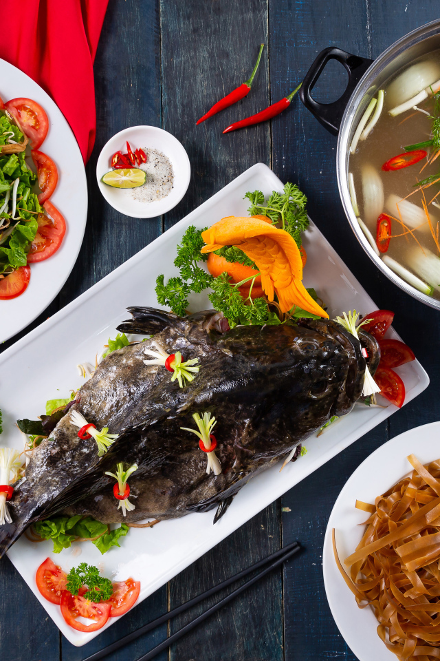 Фаршированная рыба на столе с овощами