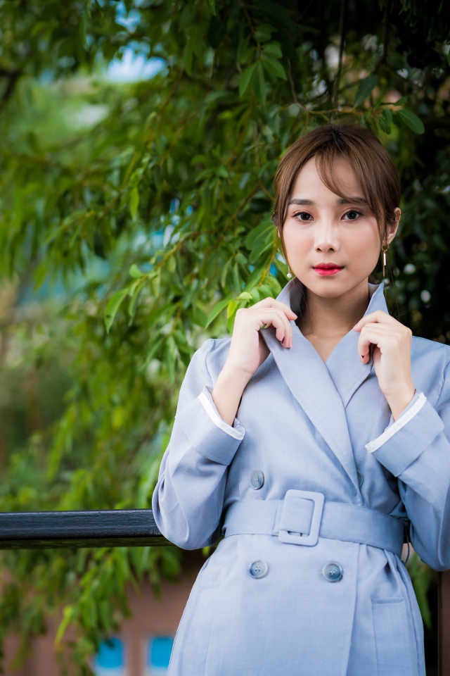 Девушка азиатка в голубом пальто в парке