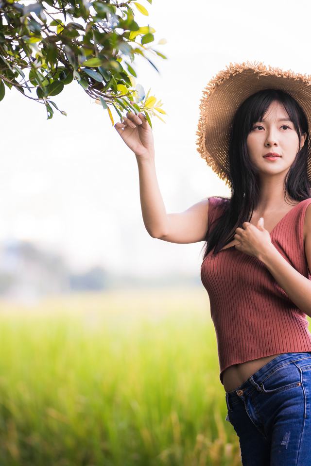 Девушка азиатка в шляпе на поле 