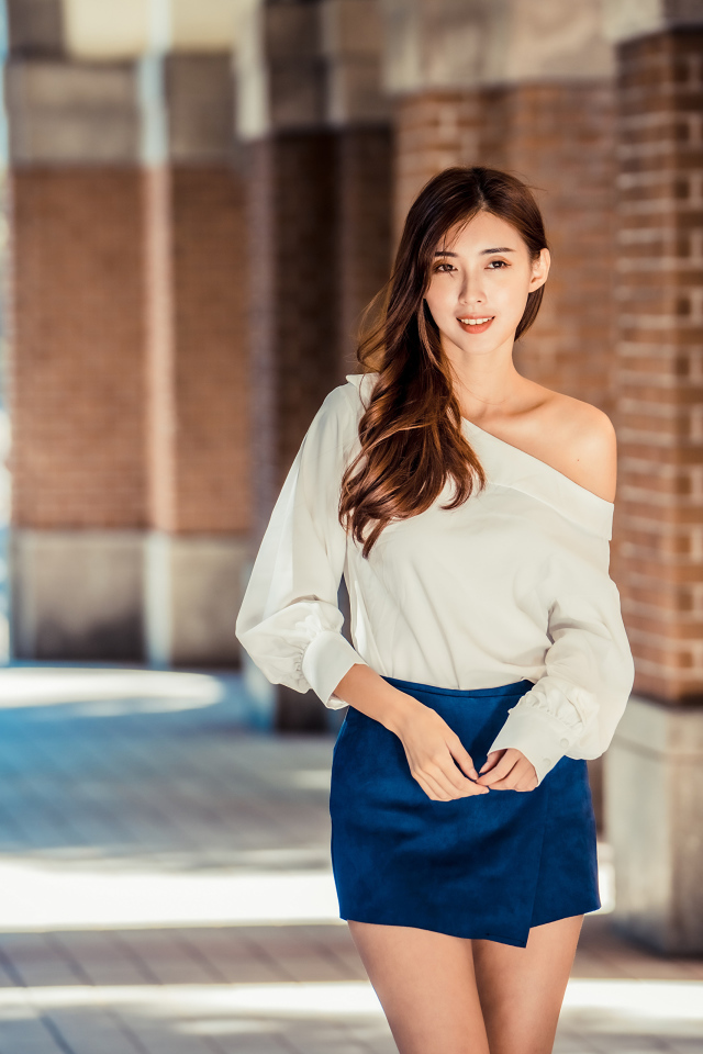 Девушка азиатка в короткой юбке у стены