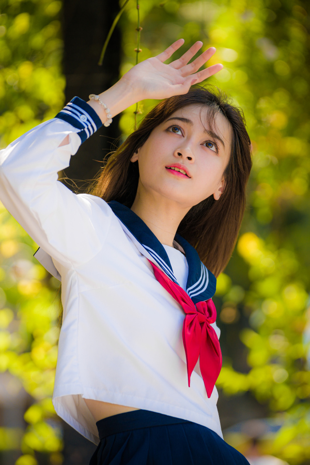 Девушка азиатка в форме с красным галстуком