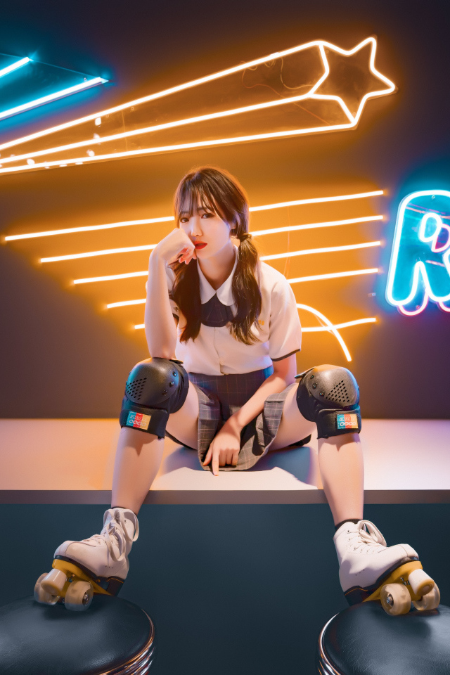 Девушка азиатка сидит в роликах на фоне вывески 