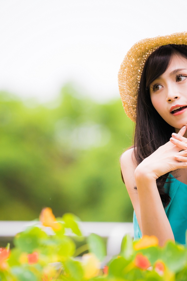 Девушка азиатка с часами на руке в шляпе