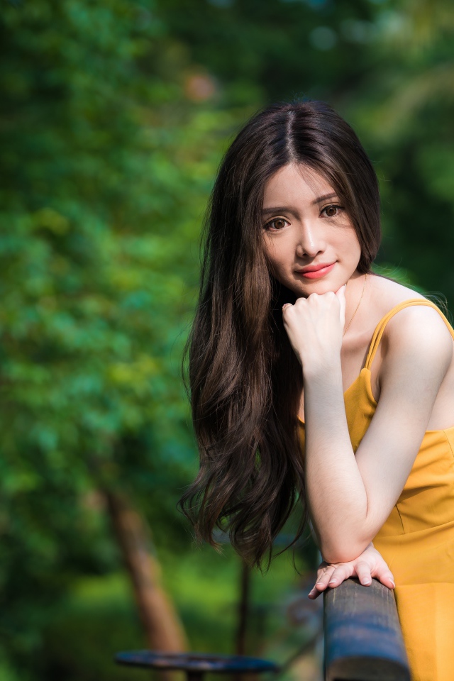 Девушка азиатка с большими карими глазами в желтом платье 