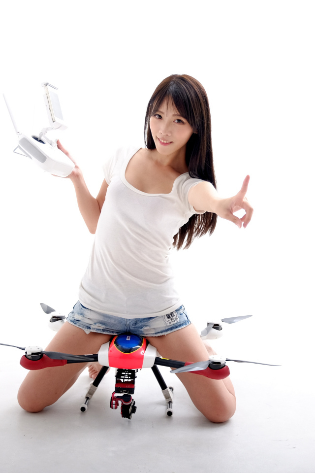 Девушка азиатка с квадрокоптером на белом фоне