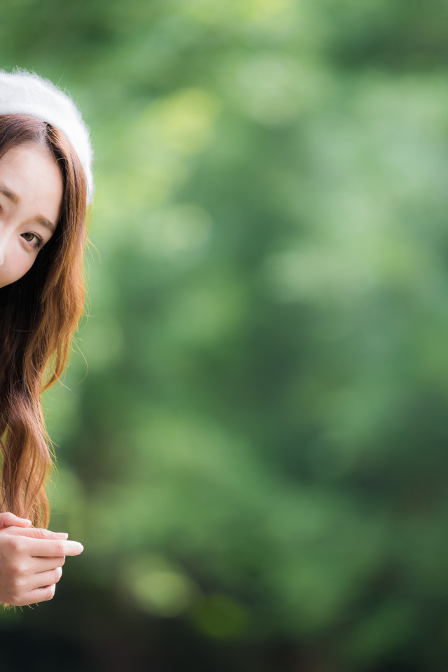 Азиатка в берете выглядывает из окна