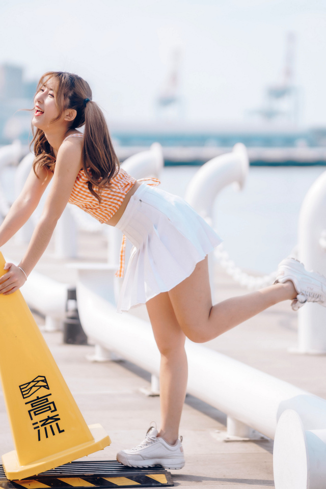 Азиатка с короткой белой юбке у воды 