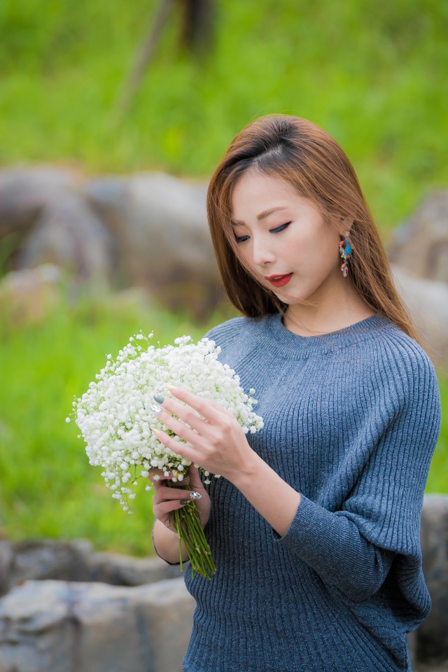 Красивая девушка азиатка держит в руках букет белых цветов