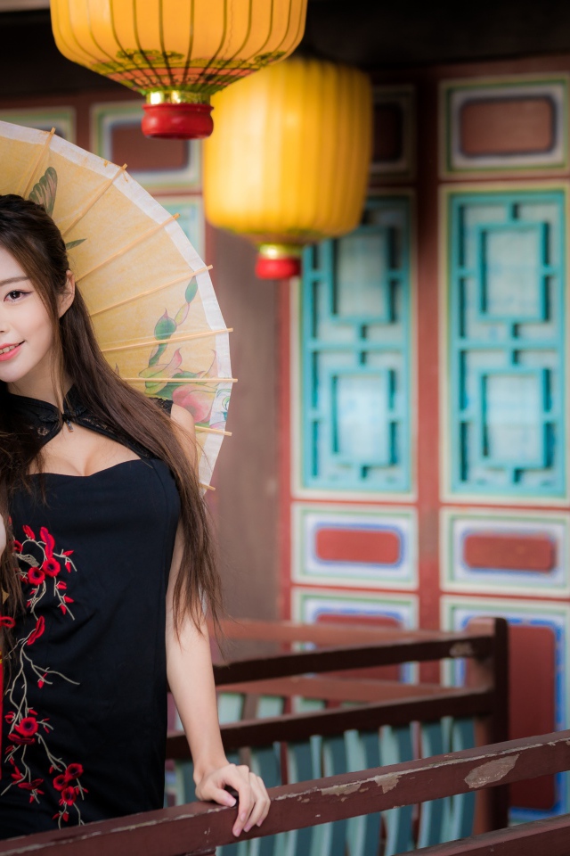 Красивая девушка азиатка в черном платье с зонтом