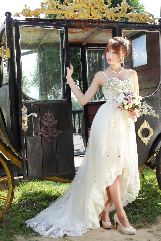 Красивая девушка азиатка в свадебном платье у кареты 