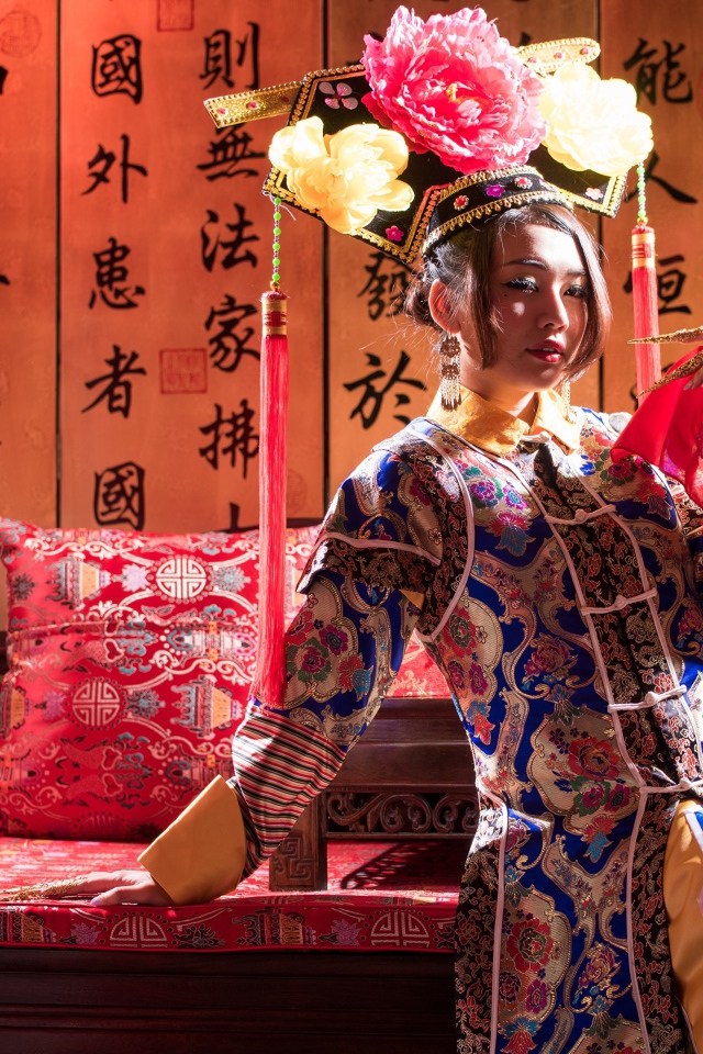 Красивая девушка азиатка в национальном костюме на диване