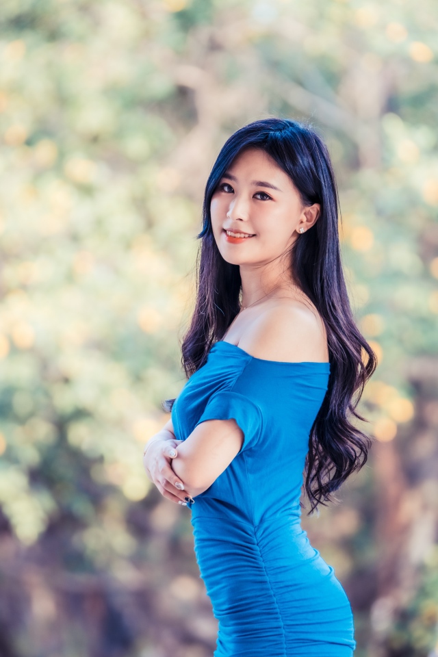 Красивая девушка азиатка с милой улыбкой в голубом платье 