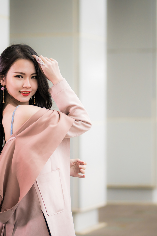 Красивая девушка азиатка с длинными волосами в розовом пальто 