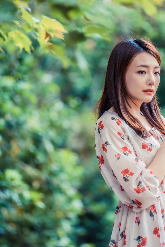 Красивая девушка азиатка в платье в парке
