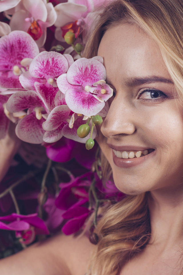 Красивая девушка блондинка с цветами орхидеи