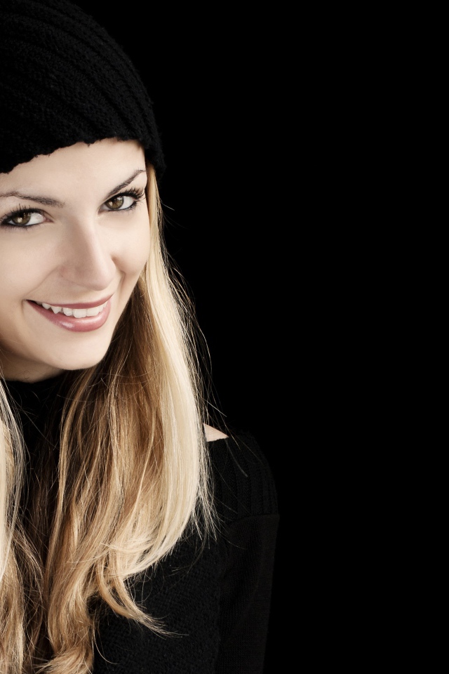 Красивая блондинка в шапке на черном фоне