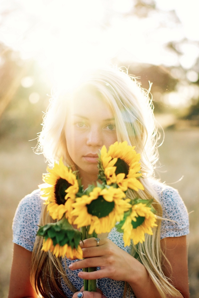 Красивая блондинка с букетом подсолнухов в руках