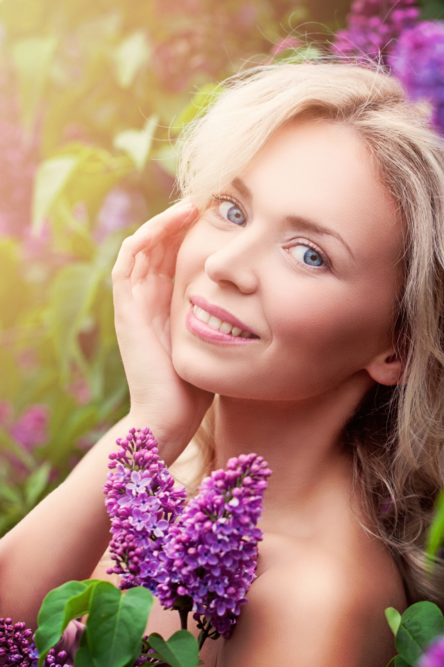 Красивая голубоглазая девушка блондинка в цветах сирени