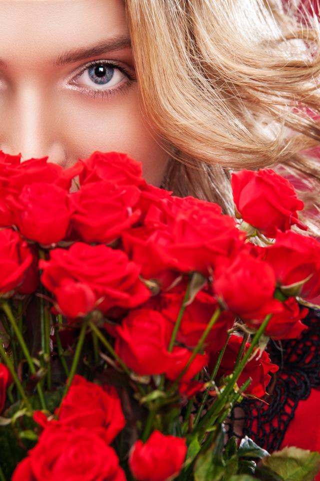 Красивая голубоглазая блондинка с букетом красных роз 
