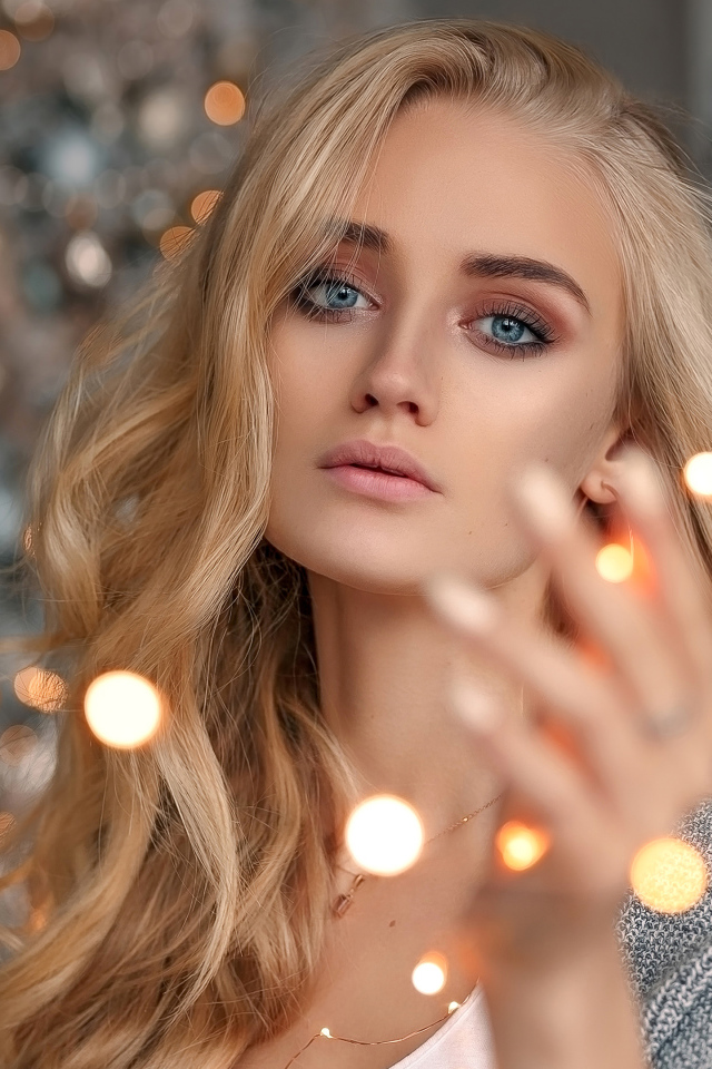 Красивая голубоглазая блондинка с гирляндой в руке