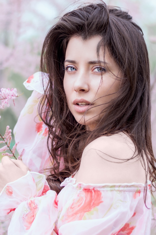 Красивая голубоглазая девушка в розовых зарослях 