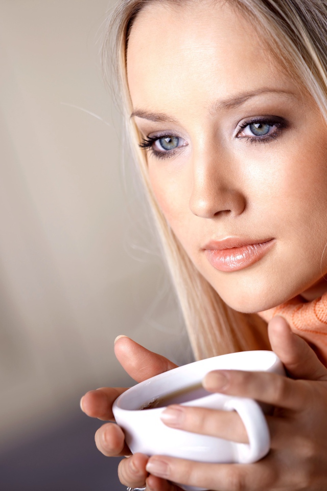 Красивая голубоглазая девушка с чашкой кофе 