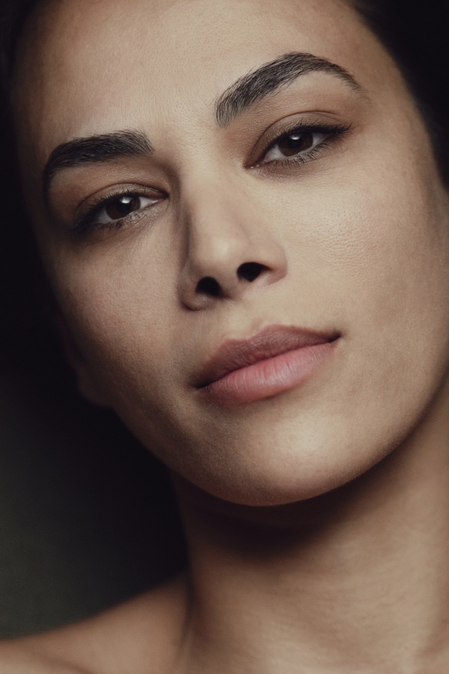 Красивая кареглазая девушка лежит на диване 