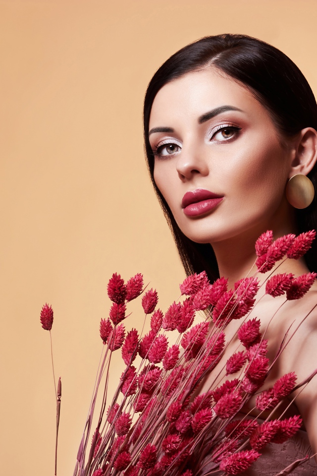 Красивая брюнетка в букетом красных цветов 