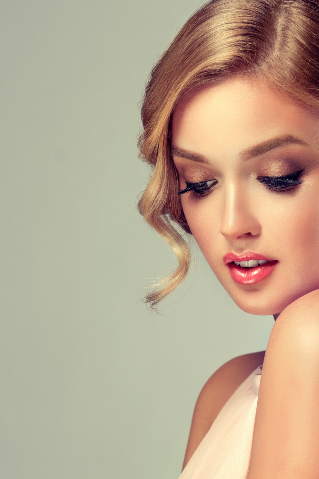 Красивая милая девушка со стильной прической на сером фоне