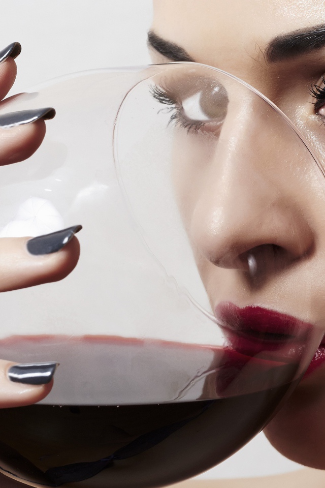 Красивая девушка пьет вино из бокала 