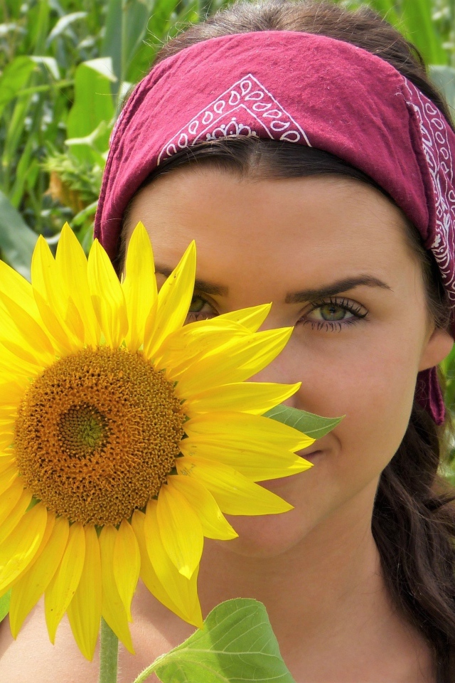 Красивая девушка держит в руках цветок подсолнуха