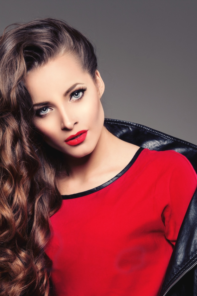 Красивая девушка в черной кожаной куртке и красном свитере