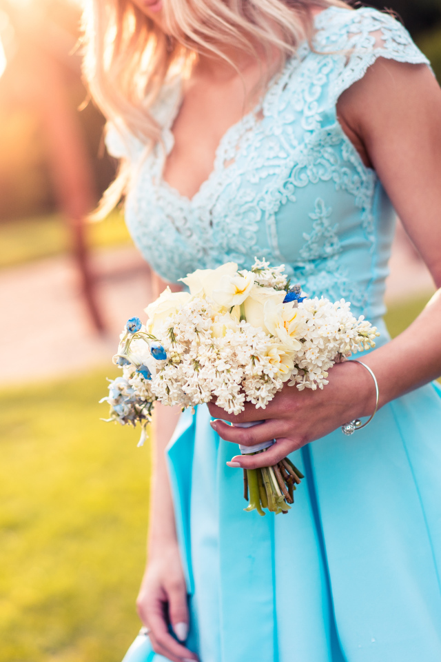 Красивая девушка в голубом платье с букетом в руке