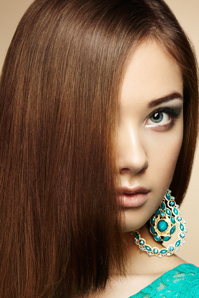 Красивая девушка в голубом платье с сережками в ушах