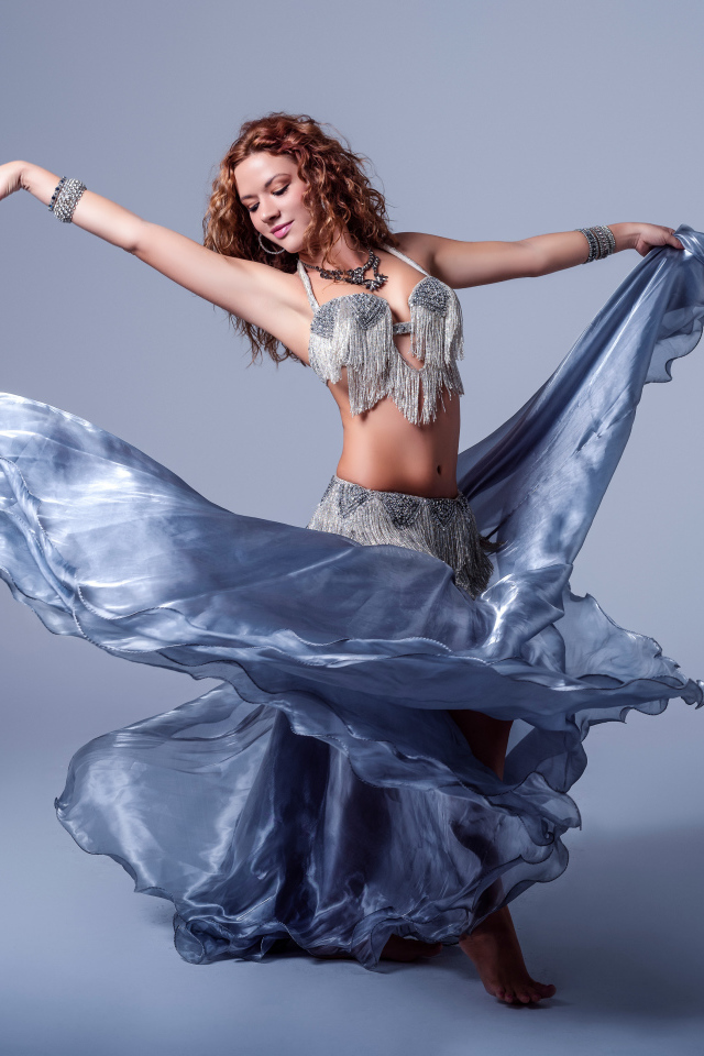 Красивая девушка в платье для танцев на сером фоне