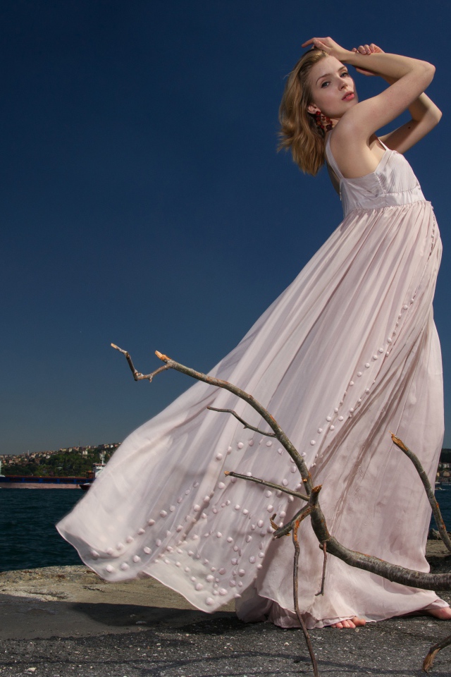 Красивая девушка в белом платье на берегу реки